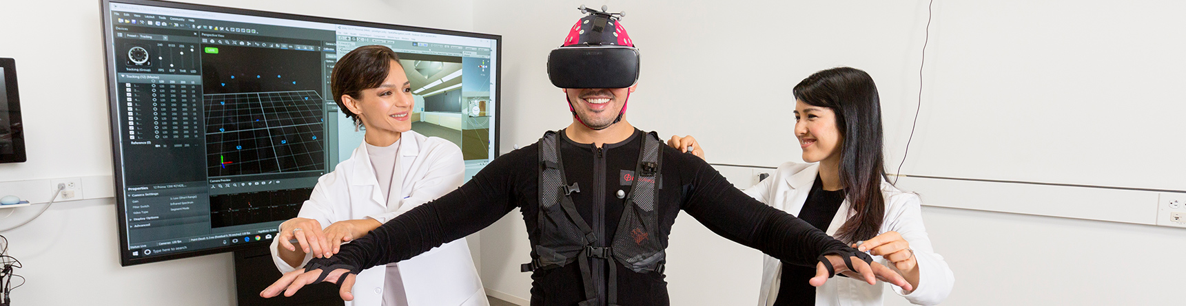 Two female researchers working with man wearing state-of-the-art virtual reality headset