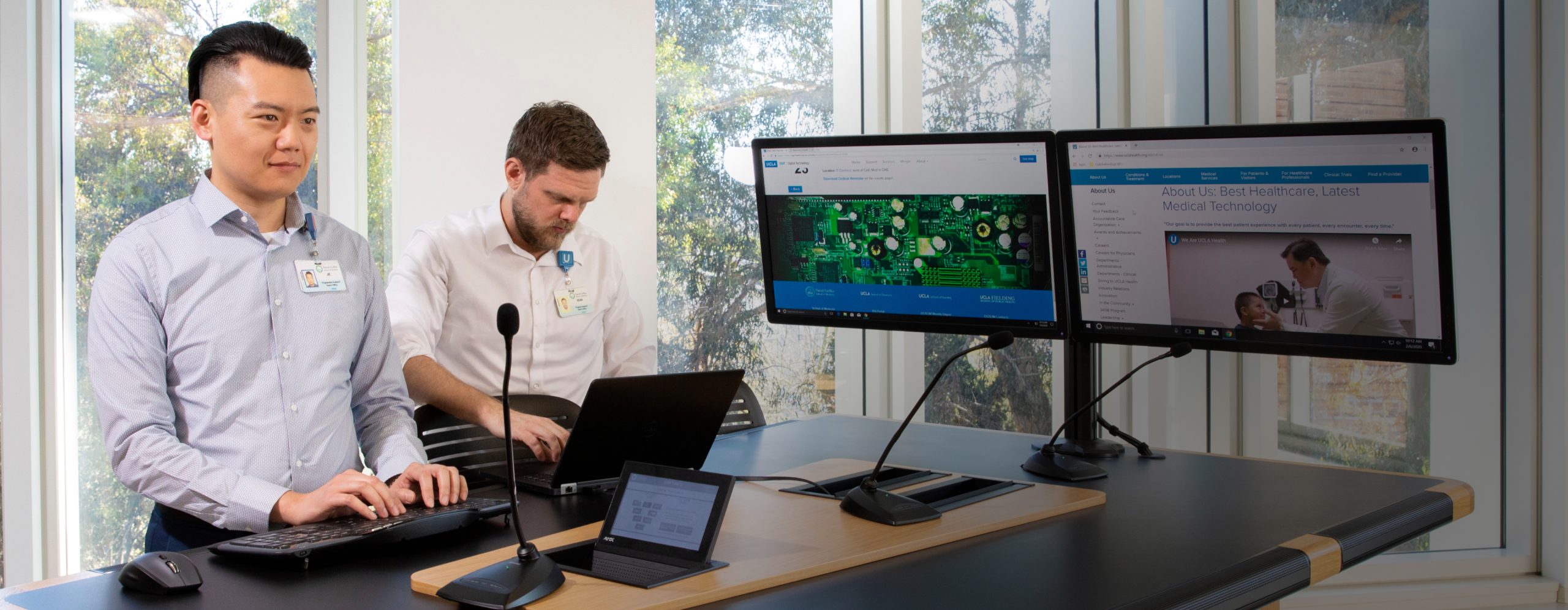 Two UCLA Health information technology professionals working at computers in an office